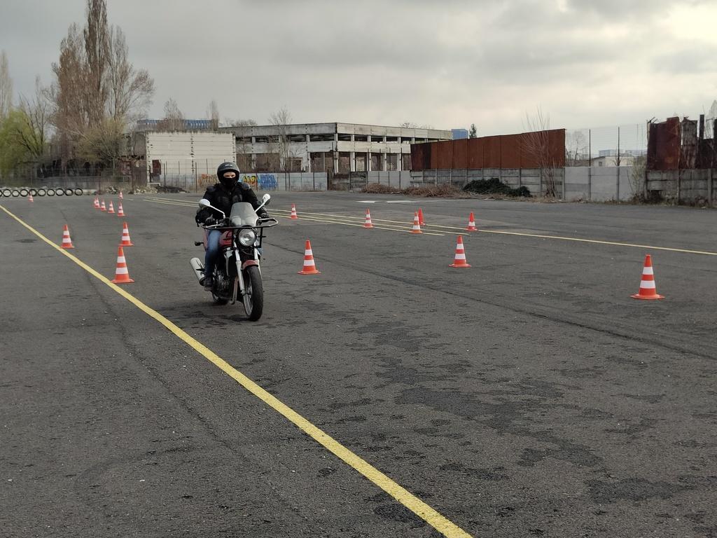 Motociclist exersând schimbarea de viteze pe poligonul Școlii de Șoferi Giulești